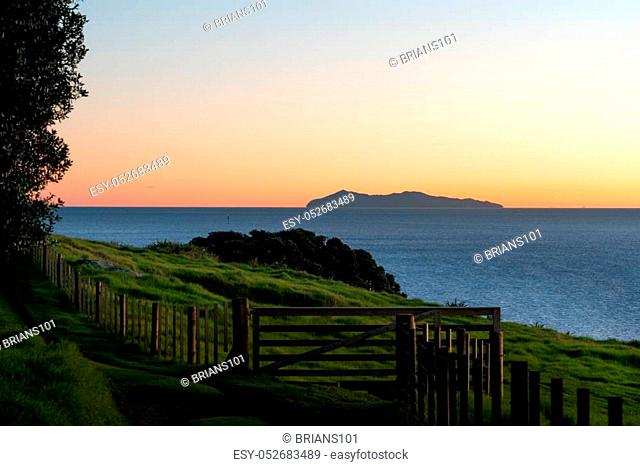 Ocean sunrise with Mayor Island on horizon viewed from lower slopes of Mount Maunganui, Tauranga