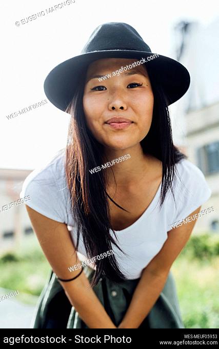 Smiling young beautiful woman wearing hat on sunny day
