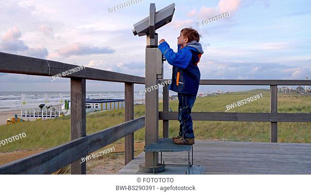 little boy with coin telescope at the North Sea, Netherlands