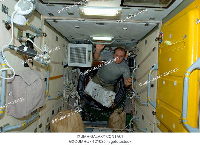 Russian cosmonaut Oleg Kotov, Expedition 22 flight engineer, is pictured near a stowage bag floating freely in the Zarya Functional Cargo Block (FGB) of the...