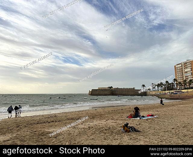 02 November 2023, Spain, Cádiz: People sitting on La Caleta beach in Cadiz. Photo: Benedikt von Imhoff/dpa. - Cádiz/Andalusia/Spain