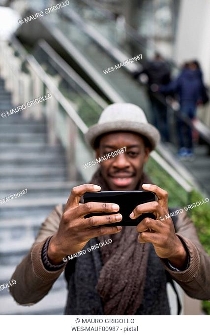 Man taking selfie with smartphone, close-up