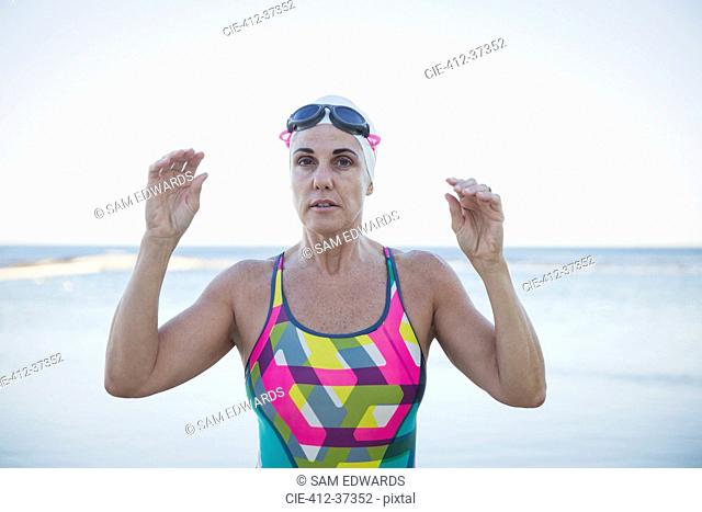 Portrait serious mature female open water swimmer at ocean
