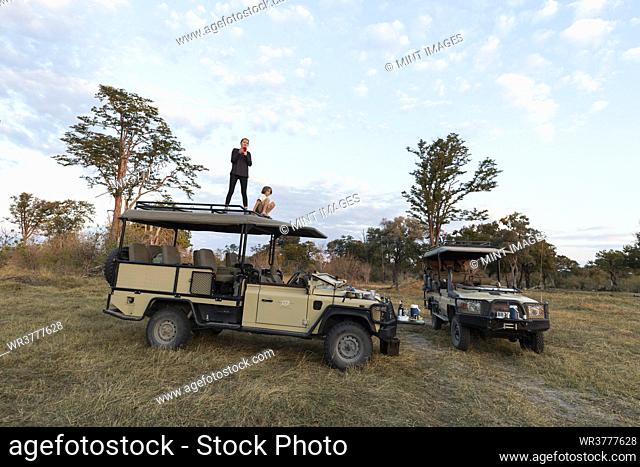 Two children on the roof of a safari vehicle on a sunrise game drive