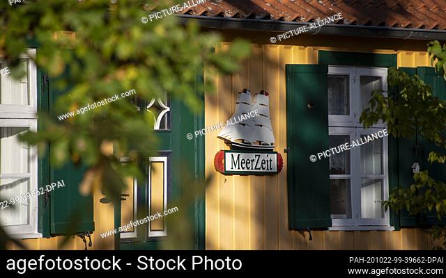 19 October 2020, Mecklenburg-Western Pomerania, Prerow: A wooden ship hangs from a traditional house on the Darß. Below it is the word sea time