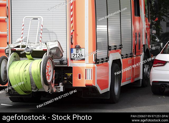 07 June 2023, Berlin: The driver of a fire department emergency vehicle works millimeters to get past a parked car in an apartment fire at Gustav-Müller-Platz...