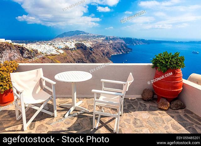 Table and chairs on roof with a panorama view on Santorini island, Greece. Caldera, Aegean sea