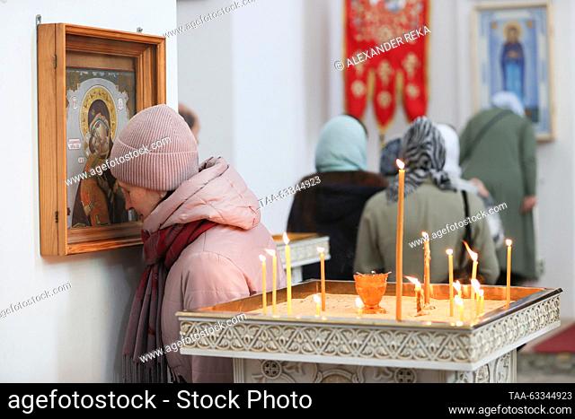 RUSSIA, LUGANSK - OCTOBER 14, 2023: A woman venerates Our Lady of Vladimir during a service at the Church of Our Lady of Tenderness to mark the Christian feast...
