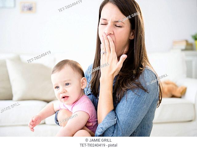 Mother with daughter 6-11 months sitting in living room