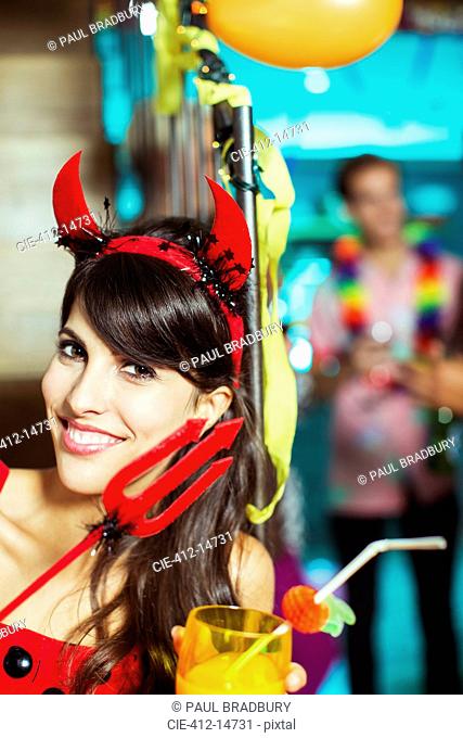 Woman wearing devil costume at party