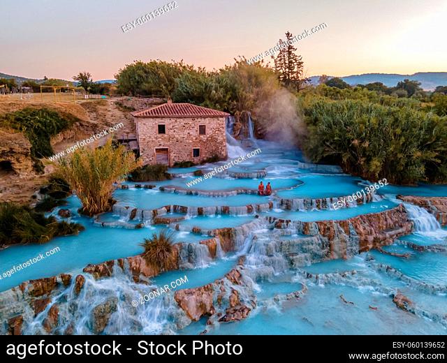 natural spa with waterfalls and hot springs at Saturnia thermal baths, Grosseto, Tuscany, Italy, Hot springs Cascate del Mulino man and woman in hot spring...