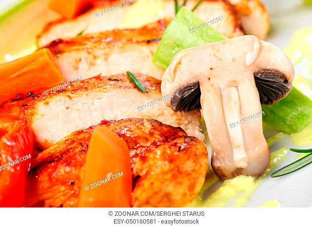 Warm salad with roasted chicken meat, vegetables and mushrooms