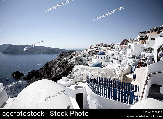 Scenic view of Oia on Santorini island with traditional cycladic, white houses and churches with blue domes over the Caldera, Aegean sea, Greece
