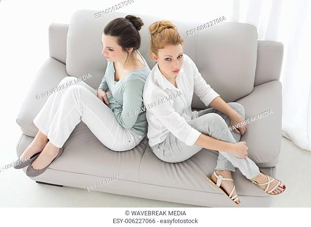 Unhappy female friends not talking after argument on the couch