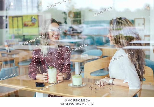 Friends in a cafe, seen through window