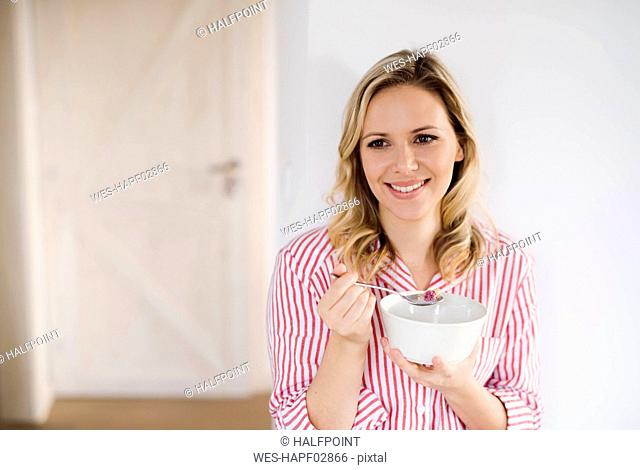 Smiling woman having breakfast in the morning at home