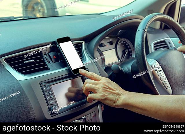 Women's hand holding a mobile phone in the car.Clipping path