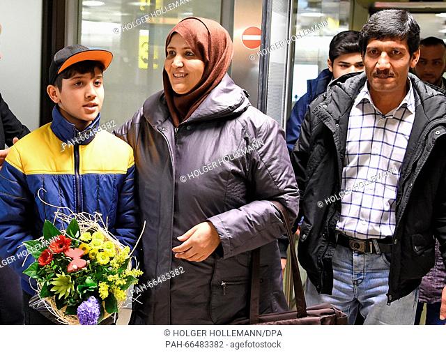Afghan refugee boy Mahdi Rabani (L-R) stands next to his mother Shockria and his father Ibrahim in the arrivals hall of the Hanover-Langenhagen Airport with a...