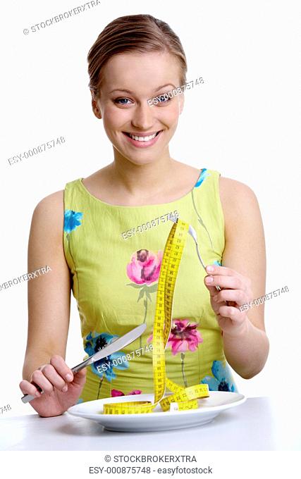 Portrait of attractive woman holding fork and knife over plate with measuring tape in it