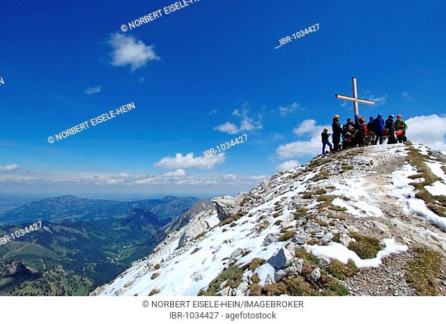 Rock climbers at a summit cross, Hindelanger climbing route, Oberstdorf, Allgaeu, Bavaria, Germany, Europe