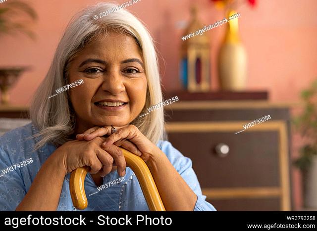 Close-up portrait of an old woman with walking stick