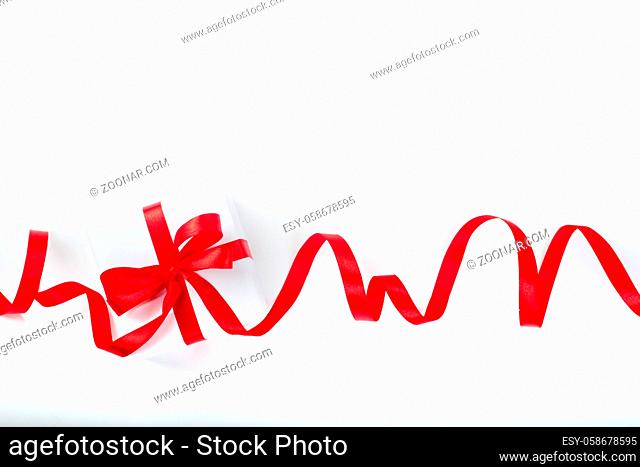 White holiday present gift box with red satin bow and curly ribbon border frame design isolated on white background , Christmas, Valentines day