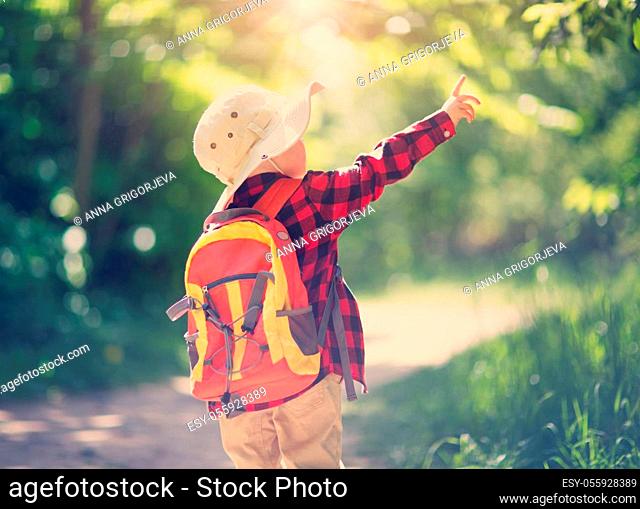 boy going camping in nature. hild with backpack walking in the forest