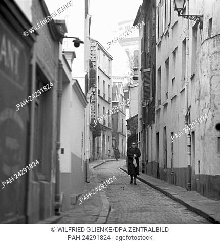 View of an alley in the quarter Montmartre in Paris, France, in November 1970. In the background, the towers of Sacre Coeur can be seen