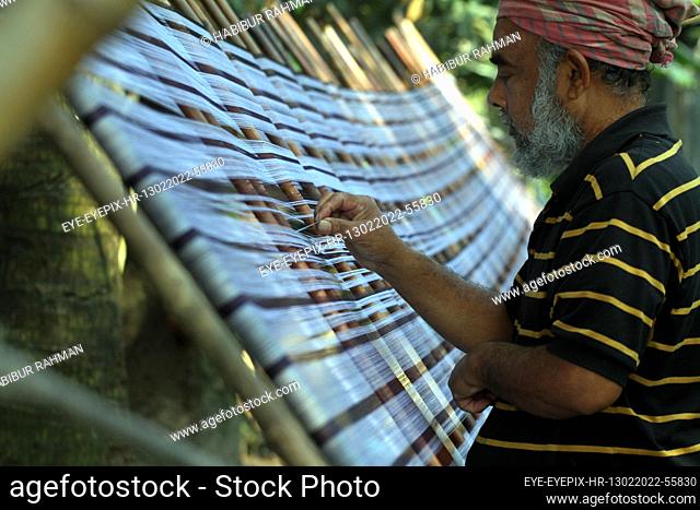 DHAKA, BANGLADESH - FEBRUARY 13, 2022: A employee work in the manufacture process of yarn to fabric production in a backyard at Keraniganj