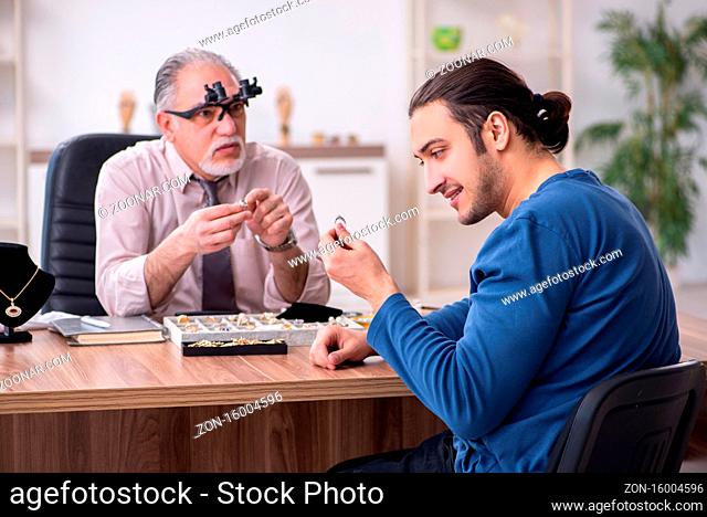 Young man visiting old jeweler