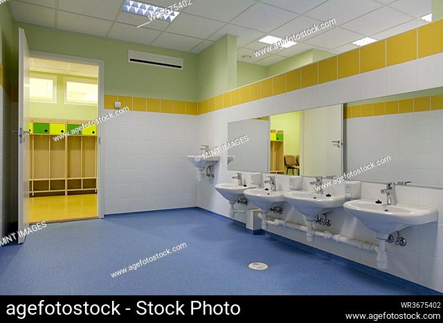 School Restroom, modern style with yellow paint and blue flooring