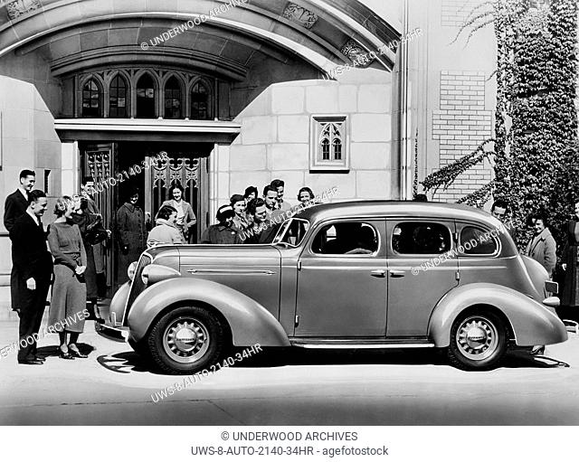United States: 1936.A crowd of people admiring a new 1936 Studebaker Dictator