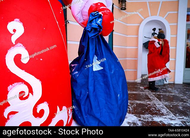 RUSSIA, RYBINSK - DECEMBER 16, 2023: A man puts on a Father Frost (Russian Santa Claus) costume outside the Rybinsk Drama Theatre before the start of a parade...