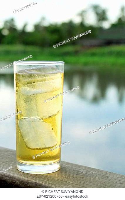 A Glass of beer with ice beside thailand river
