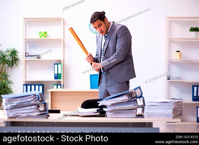 Male employee angry with excessive work holding baseball bat