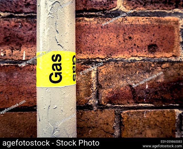 Detail Of A Residential Gas Pipe Against A Red Brick Wall