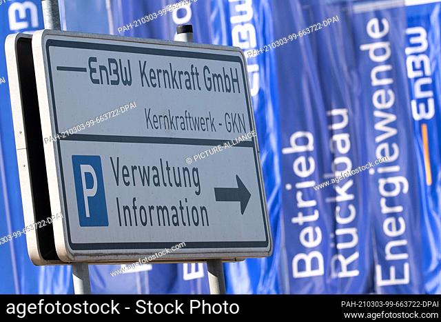 01 March 2021, Baden-Wuerttemberg, Neckarwestheim: A sign reading ""EnBW Kernkraft GmbH"" stands at the Neckarwestheim nuclear power plant in front of flags...