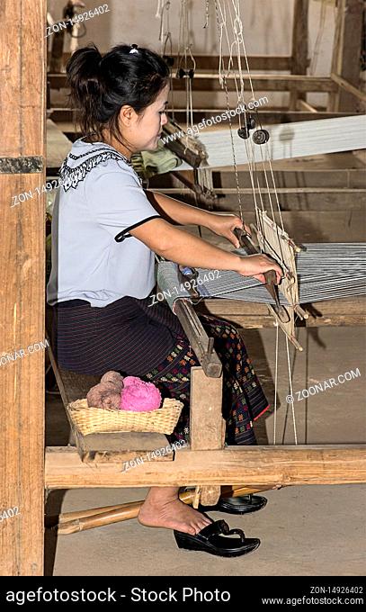 Junge Frau webt an einem traditionellen Lao-Thai Webstuhl, Ban Phanom, Laos / Young woamn weaving on a traditional Lao-Thai style loom, Ban Phanom, Laos