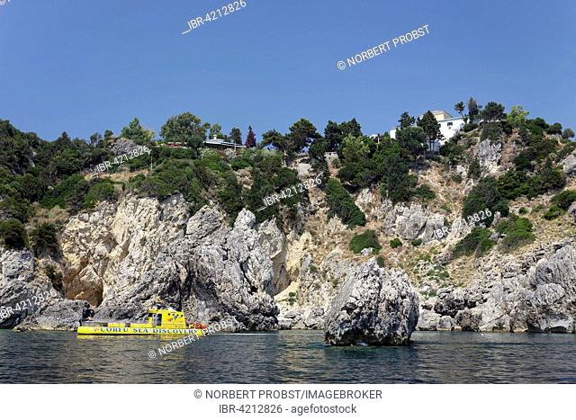 Cliffs and a glass bottom boat, Monastery of Panagia Theotokos tis Paleokastritsas above, on rocks, Paleokastrista, island Corfu, Ionian Islands, Greece