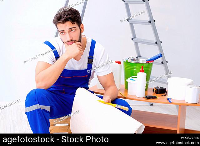 Repairman doing renovation repair in the house with paper wallpaper