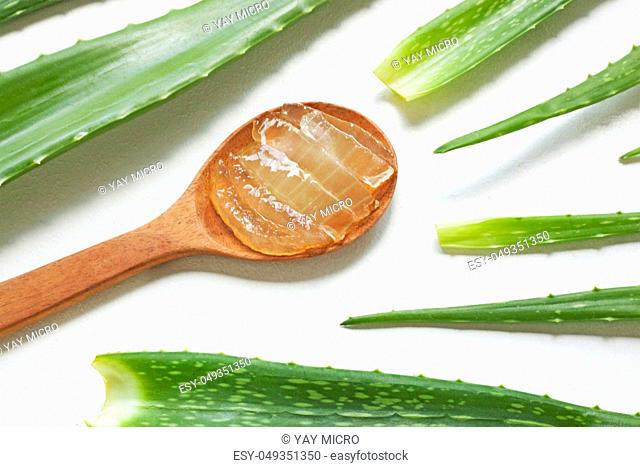 Aloe vera fresh leaves with aloe vera gel on wooden spoon. isolated on white