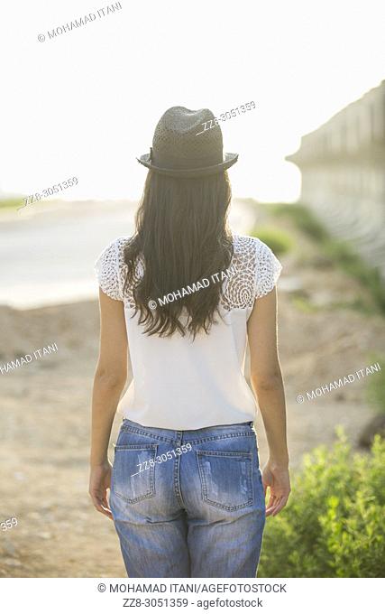 Rear view of a young woman wearing a hat standing outdoors