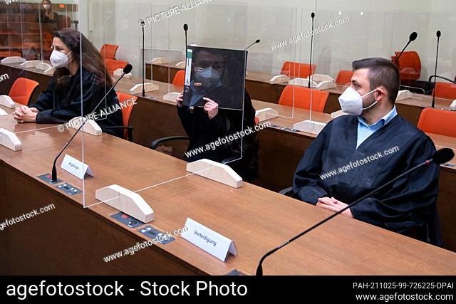 25 October 2021, Bavaria, Munich: The defendant Jennifer W. (M) and her lawyers Seda Basay-Yildiz (l) and Ali Aydin sit in the courtroom before the trial begins