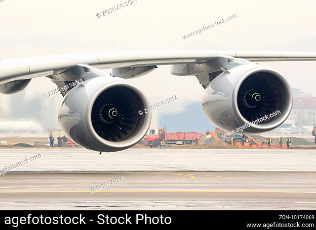 Airbus A380 airplane's engines on a wing on a runway at an airport