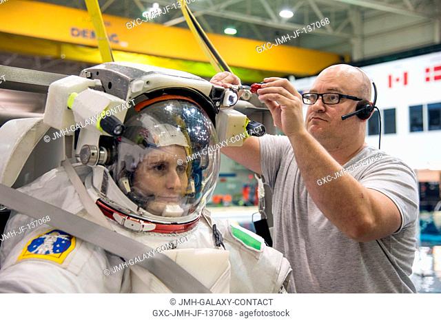 European Space Agency astronaut Samantha Cristoforetti, Expedition 4243 flight engineer, gets help with final touches on a training version of her...