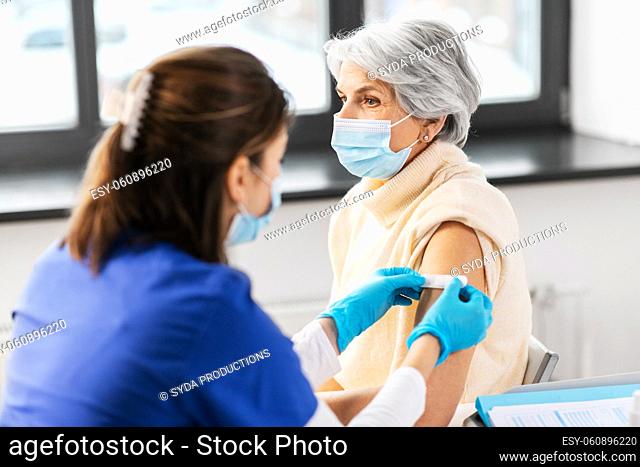 nurse applying medical patch to vaccinated woman