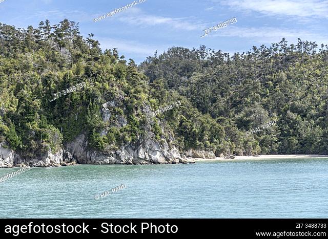 landscape with rocks, sand beach and lush rain forest vegetation, shot in bright spring light at Torrent bay, near Kaiteriteri, Abel Tasman park, South Island