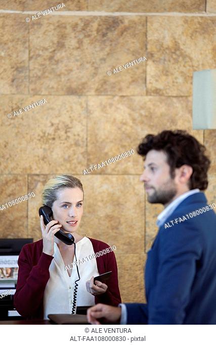 Receptionist verifying customer's credit card on the phone