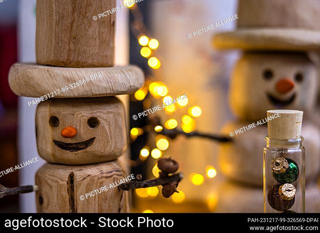 16 December 2023, Brandenburg, Leuthen: Wooden snowman figures stand at a stall at a small Advent market.Advent and Christmas markets are also held in many...