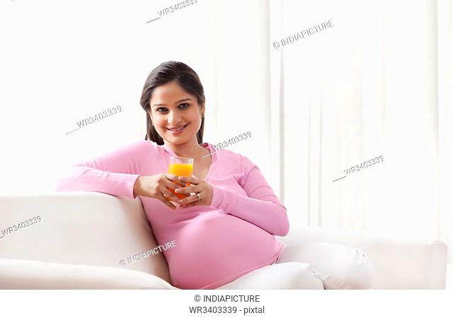 Portrait of a pregnant woman with a glass of juice